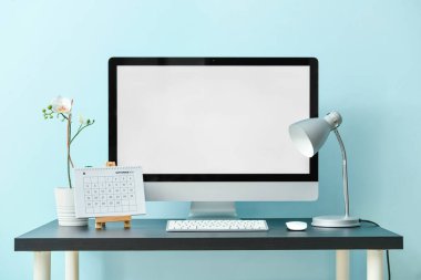 Renk duvarına yakın bilgisayar ve takvimle modern konforlu çalışma alanı