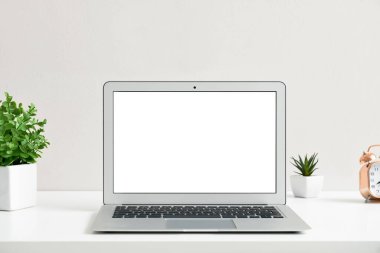 Işık arka planında modern dizüstü bilgisayarı olan rahat bir iş yeri