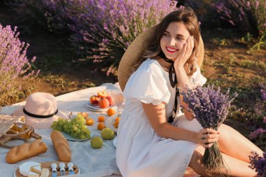 Güzel genç bayan lavanta tarlasında piknik yapıyor.
