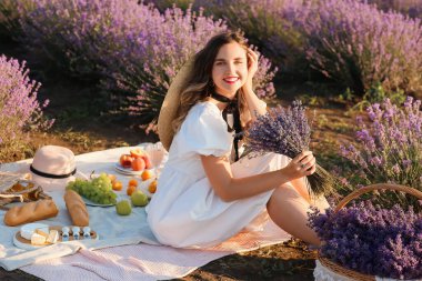 Güzel genç bayan lavanta tarlasında piknik yapıyor.
