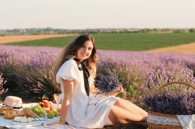 Güzel genç bayan lavanta tarlasında piknik yapıyor.