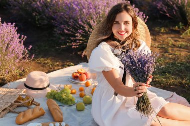 Güzel genç bayan lavanta tarlasında piknik yapıyor.