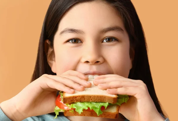小さな女の子の色の背景においしいサンドイッチを食べて クローズアップ — ストック写真