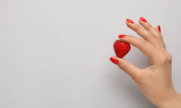 Vrouwelijke Hand Met Mooie Manicure Houden Aardbei Lichte Achtergrond — Stockfoto