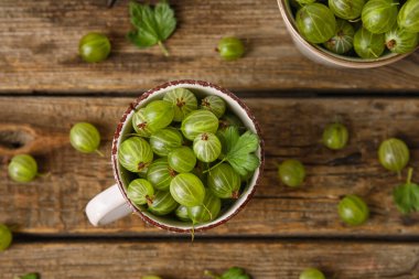 Tahta arka planda taze bektaşi üzümü dolu bir fincan.