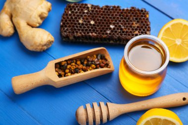 Renkli ahşap arka planda limonlu ve zencefilli farklı arı ürünleri