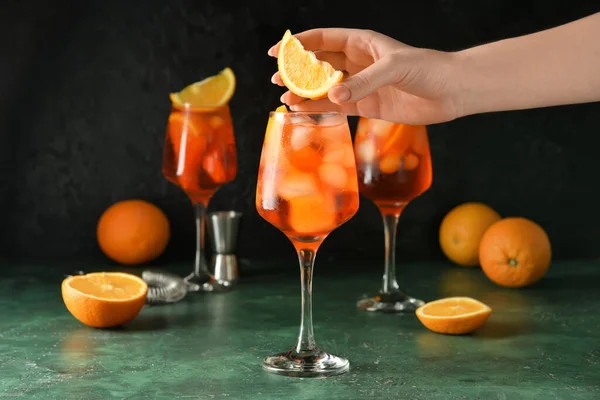 女子装饰杯子美味的开胃酒冲刺鸡尾酒与橙色在黑暗的背景 — 图库照片