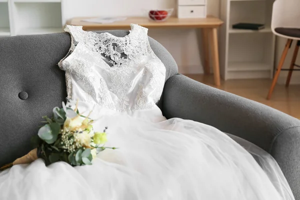 房间沙发上漂亮的婚纱和花束 — 图库照片