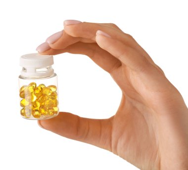 Beyaz arka planda hapları olan kadın eli ve şişesi.