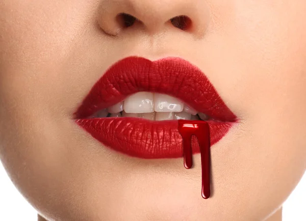 Young woman with bright red lipstick and dripping blood, closeup