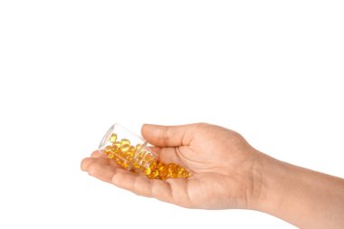 Beyaz arka planda hapları olan kadın eli ve şişesi.