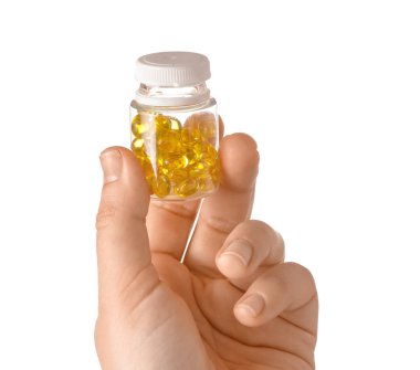 Beyaz arka planda hapları olan kadın eli ve şişesi.