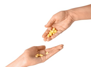 Beyaz arka planda kadın eli ve hapları