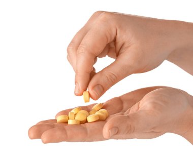 Beyaz arka planda kadın eli ve hapları