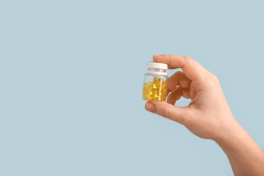 Kadın eli ve şişesi renkli haplarla dolu.