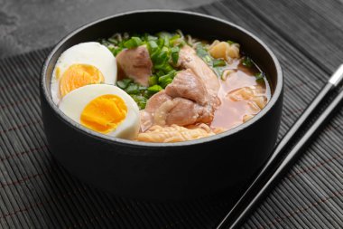 Koyu arkaplanda tavuk olan lezzetli bir Çin çorbası.