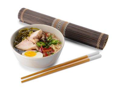 Lezzetli Çin çorbası, tavuklu kase, bambu hasırı ve beyaz arka planda çubuklar.