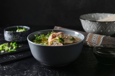 Koyu arkaplanda tavuk olan lezzetli bir Çin çorbası.