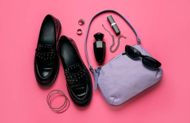 Renk arkaplanında modaya uygun el çantası ve farklı aksesuarlara sahip kompozisyon