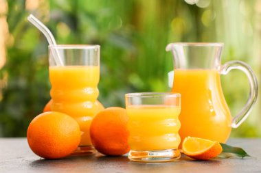 Dışarıdaki masada bir sürahi ve bir bardak lezzetli portakal suyu, yakın plan.