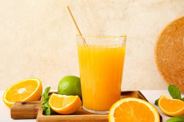 Açık arkaplanda bir bardak lezzetli portakal suyu olan tahta.