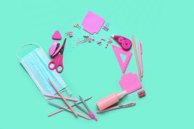 Renk arkaplanında kırtasiye malzemesi ve tıbbi maskeden yapılmış çerçeve