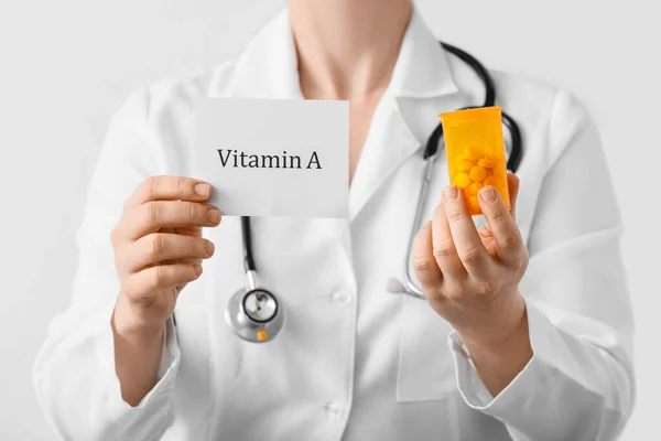 Médica Feminina Segurando Papel Com Texto Vitamina Pílulas Fundo Claro — Fotografia de Stock