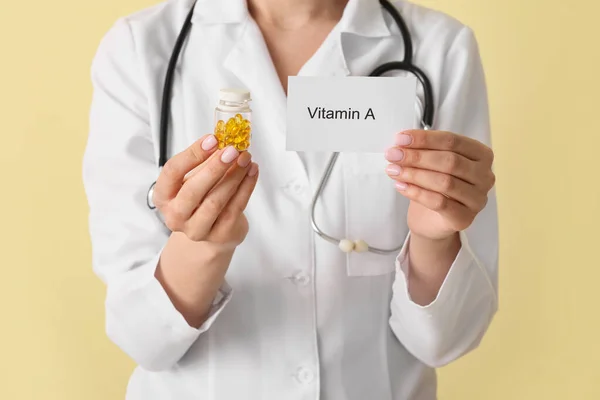 女医生持纸与文字Vitamin A和药丸的彩色背景 — 图库照片