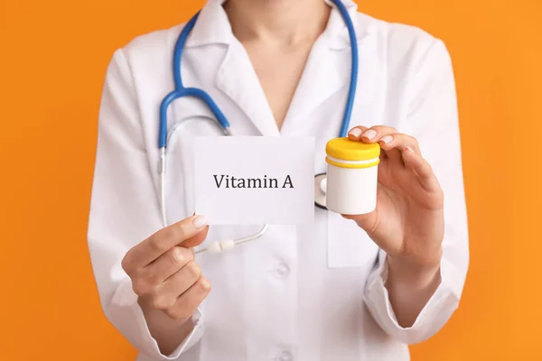 Médica Feminina Segurando Papel Com Texto Vitamina Pílulas Fundo Cor — Fotografia de Stock