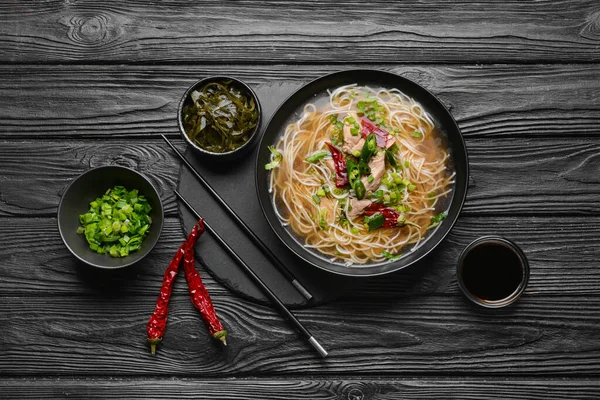 Koyu ahşap arka planda lezzetli Çin çorbası karışımı.