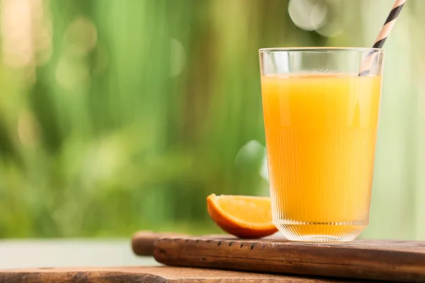 テーブルの上においしいオレンジジュースのガラスとボード屋外 — ストック写真