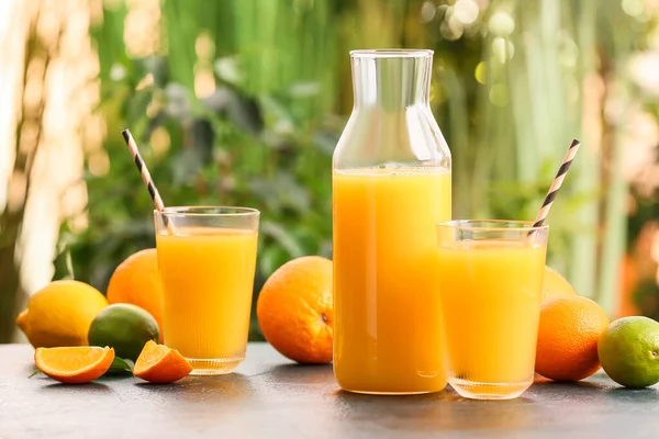 Dışarıdaki masada bir sürahi ve bir bardak lezzetli portakal suyu.
