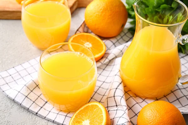 Κανάτα Και Ποτήρια Από Νόστιμο Χυμό Πορτοκαλιού Ελαφρύ Φόντο Closeup — Φωτογραφία Αρχείου