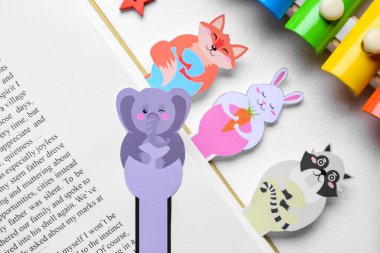 Açık arkaplanda kitap ve ksilofonu olan sevimli yer imleri