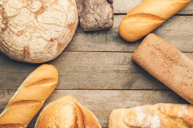 Ahşap zemin üzerinde farklı taze ekmekten yapılmış çerçeve