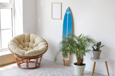 Sörf tahtası, ev bitkileri ve koltuğu olan modern şık bir oda.