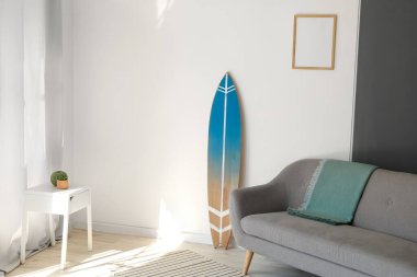 Sörf tahtası ve kanepesi olan modern şık bir oda.