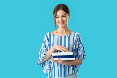 Renkli arka plan kitapları olan genç bir kadın.