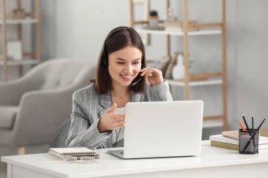 Evde dizüstü bilgisayarı olan genç bir kadın.