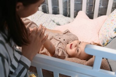 Evde beşikte bebeği olan bir anne.