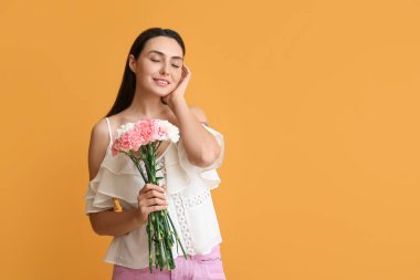 Güzel karanfil çiçekleri olan genç bir kadın.