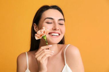 Arka planda karanfil çiçeği olan genç bir kadın.