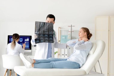 Klinikte hastayla çalışan genç bir doktor.