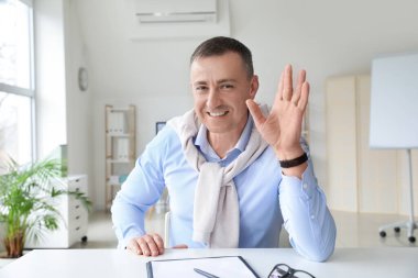 Olgun adam ofisinde görüntülü konuşma.