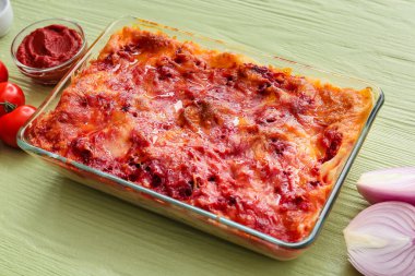 Renkli ahşap arka planda lezzetli sebze lazanyalı fırın yemeği.