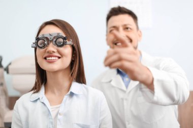 Klinikteki göz doktorunu ziyaret eden genç bir kadın.