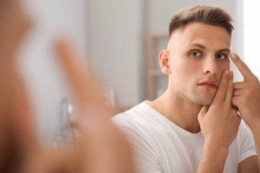 Genç adam evde kontak lens takıyor.