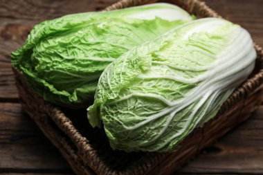 Tahta arka planda taze Çin lahanası olan sepet, yakın plan.