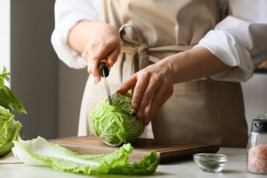 Masada taze Çin lahanası kesen kadın, yakın plan.