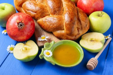 Renkli ahşap arka planda meyveli bal ve challah. Rosh hashanah (Yahudi Yeni Yılı) kutlaması